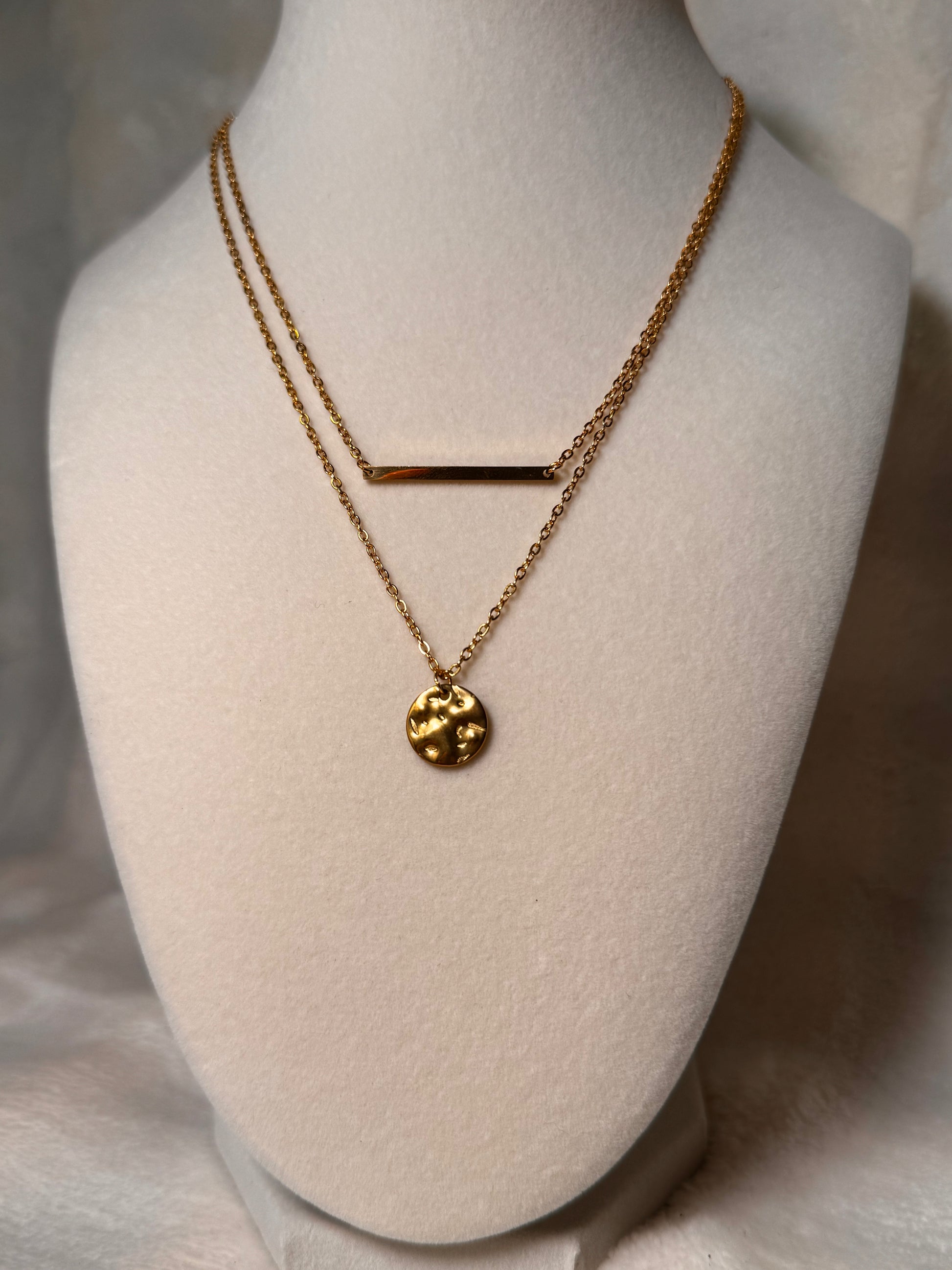  The necklace has a distinctive pendant that appears to be a stylized representation of the Earth, adding an artistic touch to its appearance.