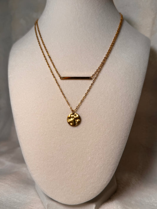  The necklace has a distinctive pendant that appears to be a stylized representation of the Earth, adding an artistic touch to its appearance.